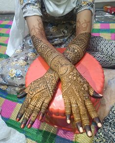 a woman sitting on top of a bed covered in henna