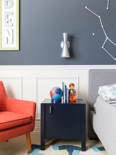 a living room with two chairs and a table in front of a wall that has the zodiac sign on it