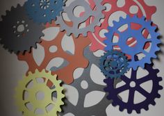 several different colored gears on a white surface