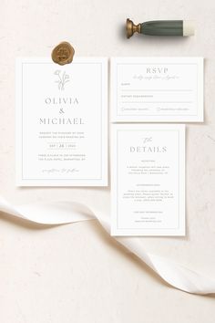 the wedding stationery is laid out on top of a white tablecloth and ribbon