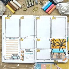 an open planner spread out with markers, pens, and other items on the table