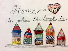 a white t - shirt with some houses on it and a heart above the words home is where the heart is