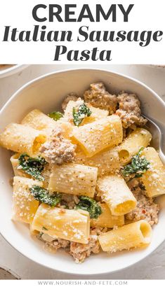 creamy italian sausage pasta with spinach and parmesan cheese in a white bowl