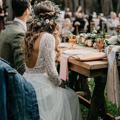 a man and woman sitting at a table with flowers in their hair