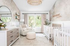 a baby's room with a white crib, dresser and mirror on the wall