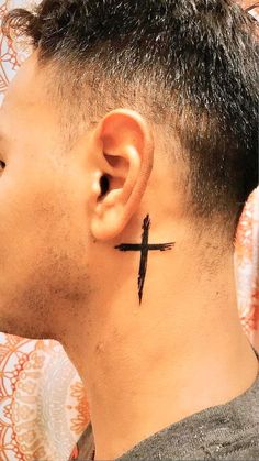 a man with a cross tattoo on his ear