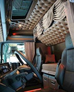 the interior of a vehicle with leather seats and an entertainment system on the wall above it