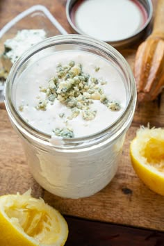 a glass jar filled with yogurt next to sliced lemons