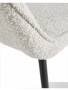 a close up of a white chair with black legs