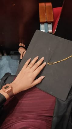 a woman's hand resting on top of a book with a gold chain attached to it