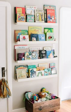 there is a book shelf with many books on it and a wooden crate in front of the wall