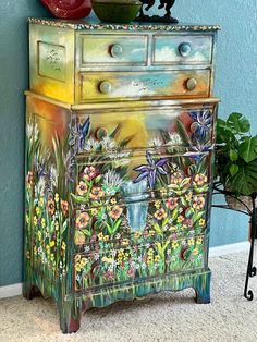 an old dresser painted with flowers and plants