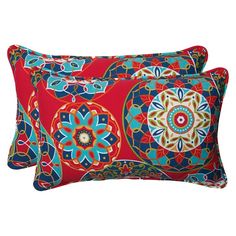 two red and blue decorative pillows on a white background, one has a flower design