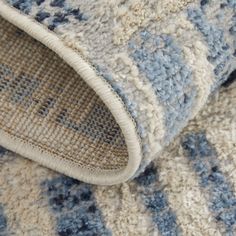 a close up view of a blue and white rug on the floor with an area rug underneath it