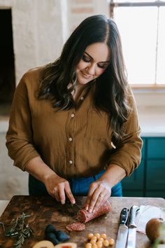 a woman is preparing food on a cutting board