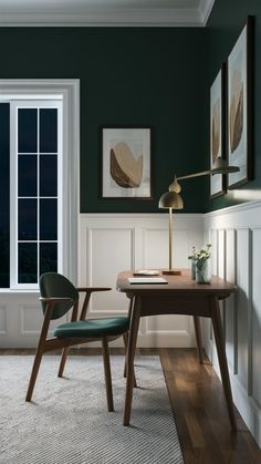 a room with green walls and white trim on the windowsill is furnished with a desk, chair, and lamp