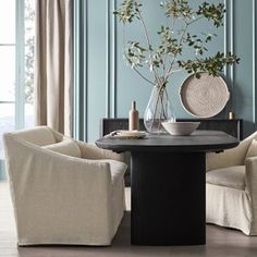 a dining room with blue walls and white chairs