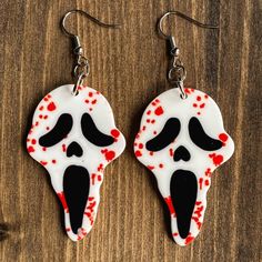 the earrings are decorated with red and white icing, while the skull is painted black