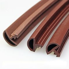 three pieces of brown colored wood on a white surface