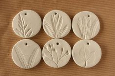 four white ceramic ornaments with leaves on them