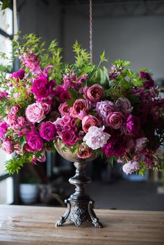 a vase filled with pink flowers on top of a wooden table