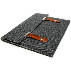 an ipad case with a leather handle and some fabric on the front, sitting on a white surface