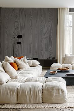 a living room filled with white furniture next to a large window on top of a hard wood floor