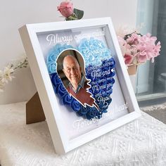 a photo frame with an image of a man's face on it and flowers in the background