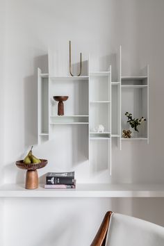 a white shelf with books, vases and other items on it's shelves