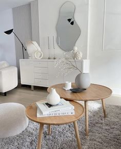 a living room with two tables and a mirror on the wall