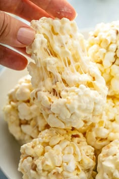 a person is scooping popcorn out of a bowl