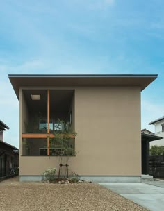 the house is made out of concrete and has a small tree in front of it