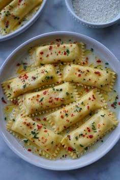 two white plates filled with ravioli and sprinkles