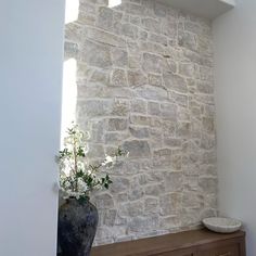 a vase sitting on top of a wooden dresser next to a window in a room