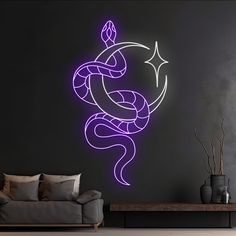 a living room with a couch, table and purple wall decal in the shape of a snake