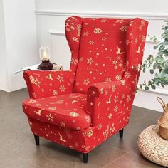 a red chair sitting on top of a tile floor next to a potted plant