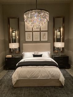 a bedroom with a large bed and chandelier hanging from it's ceiling