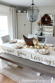 the table is set with white pumpkins and place settings for thanksgiving dinner tablescape