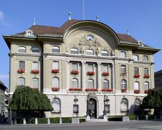 an old building with many windows and flowers on the top floor, in front of a blue sky