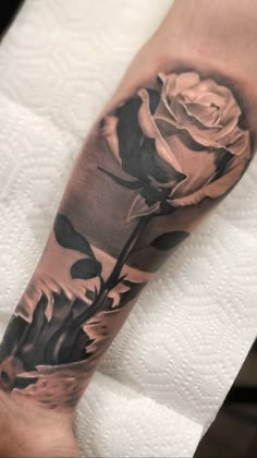 a black and white rose tattoo on the arm