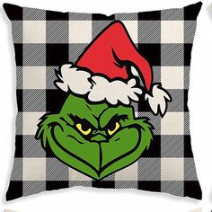 the grin face wearing a santa hat on a black and white checkerboard pillow