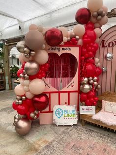 a booth with balloons and heart shaped decorations