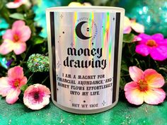 a white coffee mug with the words money drawing on it next to some pink flowers