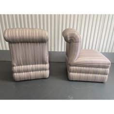 a pair of striped chairs sitting next to each other on top of a gray floor