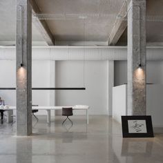 an empty room with tables, chairs and pictures on the wall in front of them