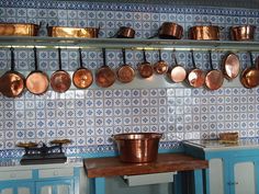 copper pots and pans are hanging on the wall