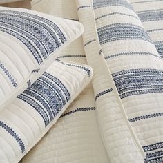 two pillows are stacked on top of each other with blue and white designs in them