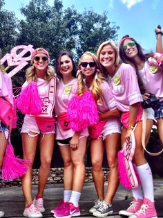 a group of women in pink outfits posing for a photo