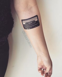 a woman's arm with a tape recorder tattoo on it