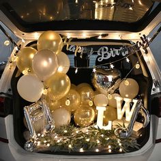 the trunk of a car decorated with balloons and streamers for a new year's eve party